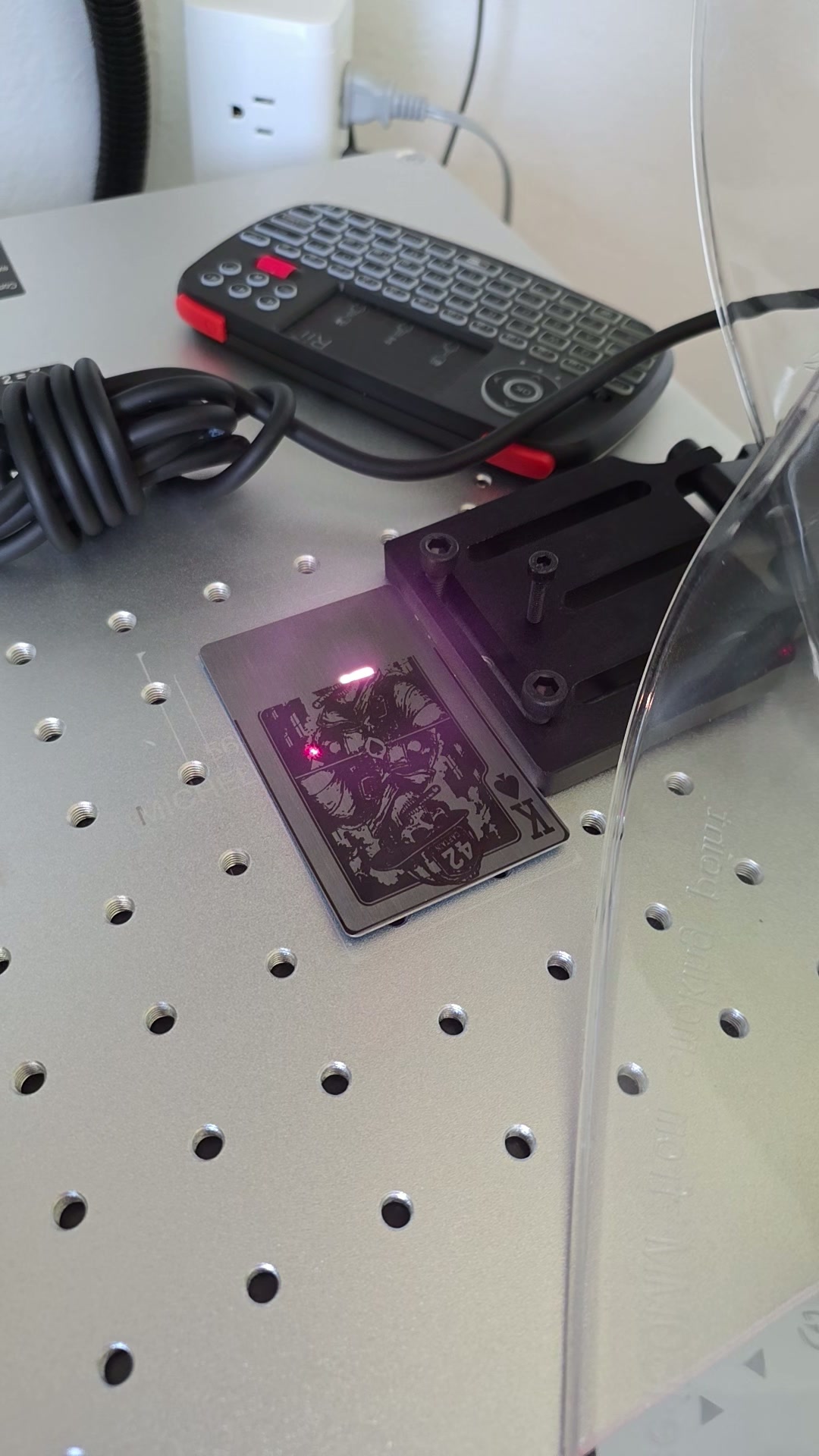 Laser engraving a metal playing card in the workshop